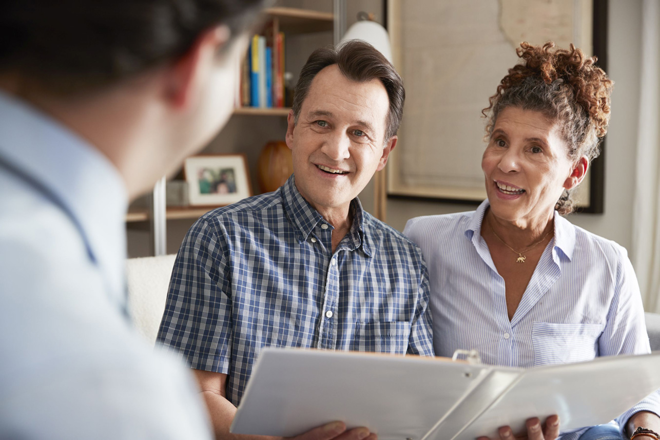 Senior Couple Meeting With Male Financial Advisor At Home